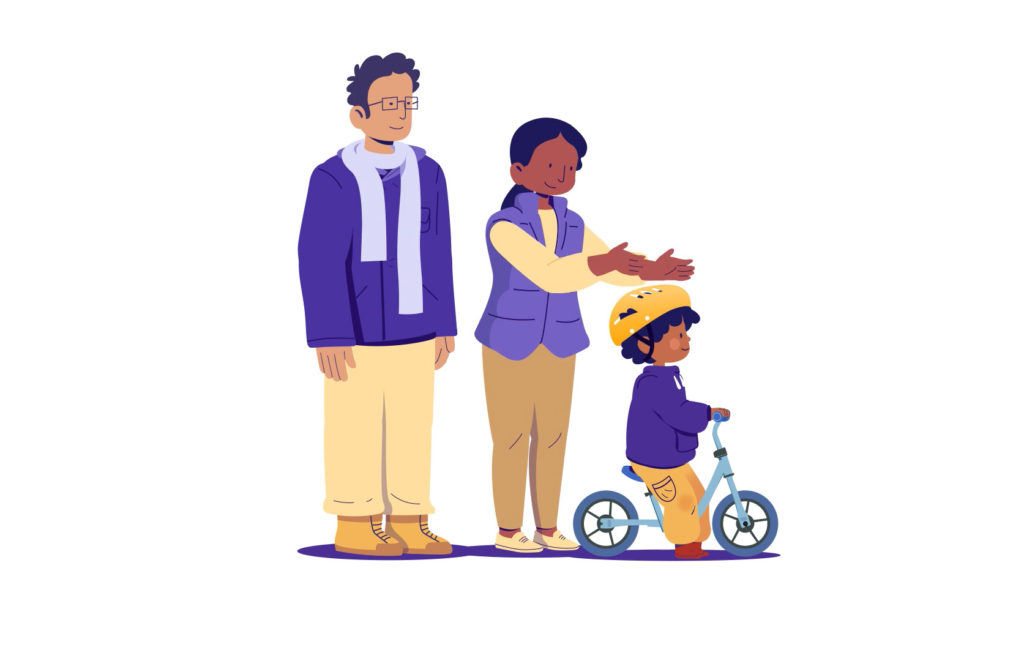 Illustration of a smiling family watching a young child ride a balance bike, with the child wearing a yellow helmet and the parents standing supportively behind.