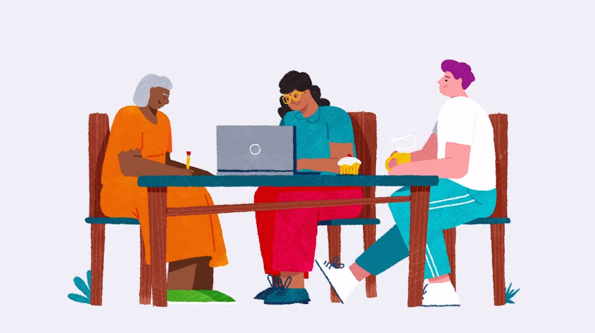 Three people sit around a table with a laptop and cupcakes, working or collaborating. The diverse group includes an older woman, a person in glasses, and another with bright purple hair.