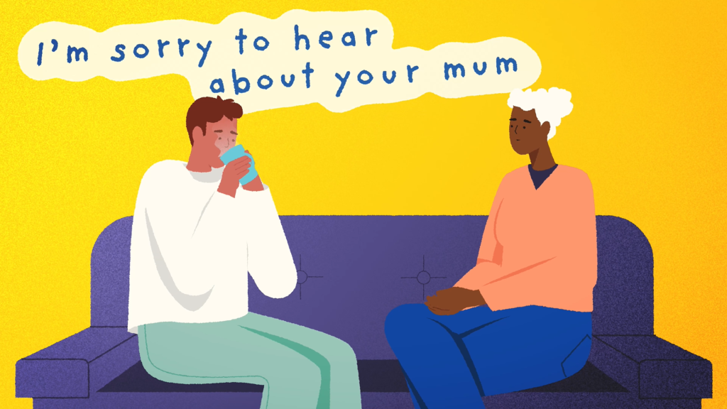 Two colleagues sitting on a sofa, one offering comfort with a hot drink and the words “I’m sorry to hear about your mum.”